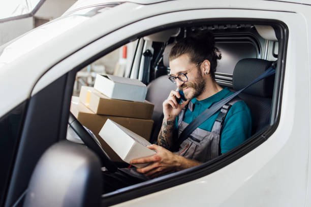 istock Delivery truck driver talking on the phone with a customer 1322846887