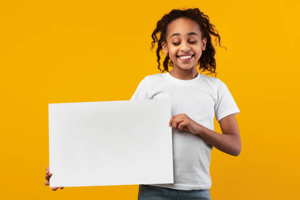 istock Black girl holding blank white advertising billboard at studio 1322847615