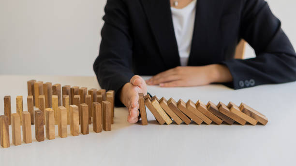 istock risk control concept A businessman defends a falling wooden block and a construction business risk strategy to select and protect the wooden blocks that line up on the table. 1322848496