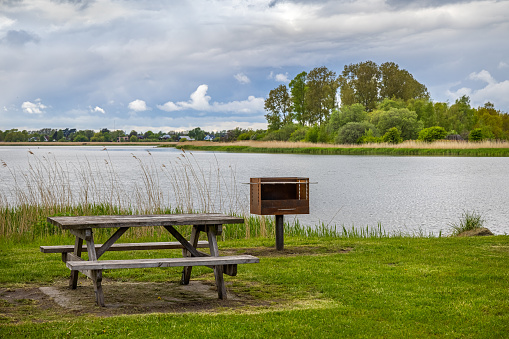 Bench, table and a grill with a view over the water in a public park in Ishøj which is a suburb south of Copenhagen