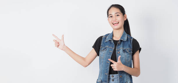 istock Asian Young woman gesture posing on white background. represent cheerful and confident. Showing gestures such as mini heart Okay Thumb up or point out. Happy amazed excited and surprised Jacket jeans. 1322848810