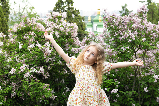 Portrait of a cute preschool girl with eye glasses outdoors in park. Happy funny child on sunny summer day