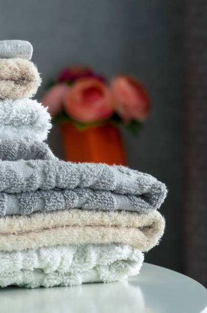 istock A stack of terry shower towels on a white table close-up. 1322849610