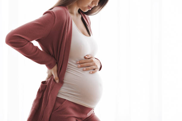 妊娠の痛み.自宅で気分が悪い若い妊娠中の女性のクロップドショット - human pregnancy backache massaging back ストックフォトと画像