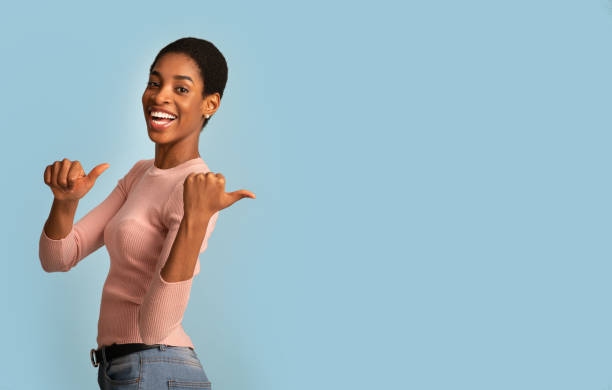 istock Cool Offer. Cheerful Young Black Female Pointing Back With Two Thumbs Up 1322851439