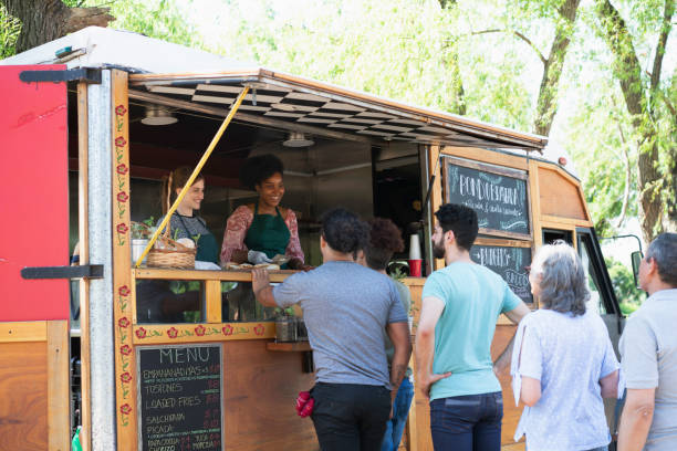 people making line to buy food from food truck stock photo