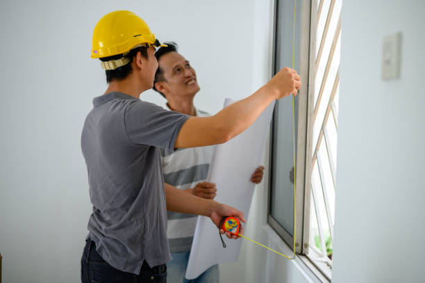 istock Construction workers using tape measure on window in the house with clients 1322851630