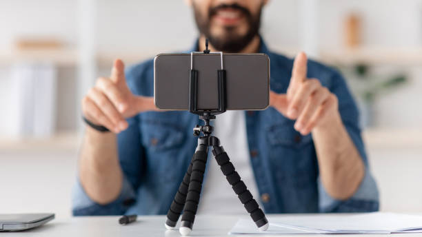 istock Modern devices for hobby. Unrecognizable young blogger making podcast, recording video and gesturing to webcam, crop 1322851701