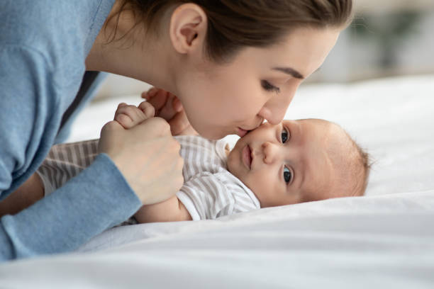 istock Young beautiful mom playing in bed with her adorable baby 1322852563