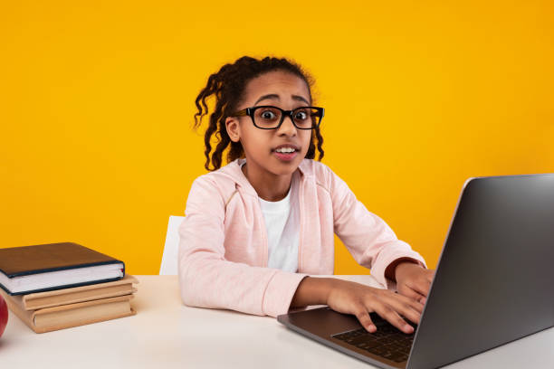istock Shocked black girl using laptop looking at camera 1322853899