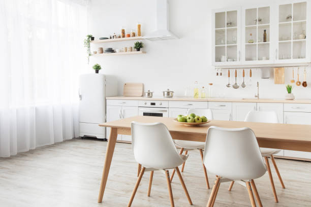 istock Modern kitchen interior. Wooden dining table, white chairs and furniture with utensils, empty space 1322854100