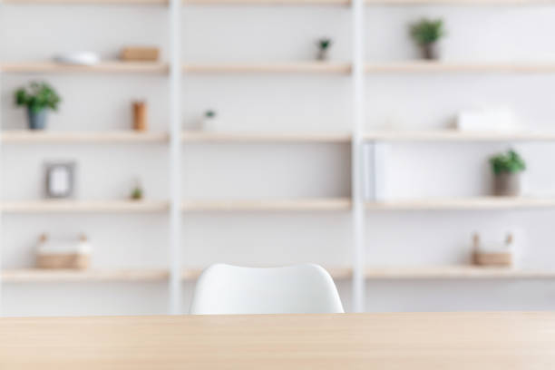 Workplace of employee, blogger, doctor in clinic or home office Workplace of employee, blogger, doctor in clinic or home office. Wooden table and chair, nobody. Shelf with plants in pots and decorative elements, on white wall background, in daylight, empty space bookshelf stock pictures, royalty-free photos & images