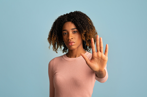 No Discrimination. Portrait Of Serious Young Black Woman Showing Stop Gesture At Camera, Millenial African American Female Standing With Outstretched Hand, Isolated Over Blue Background, Copy Space