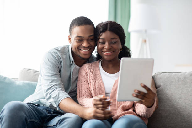 istock Relaxed african american family using digital tablet together, taking selfie 1322856224