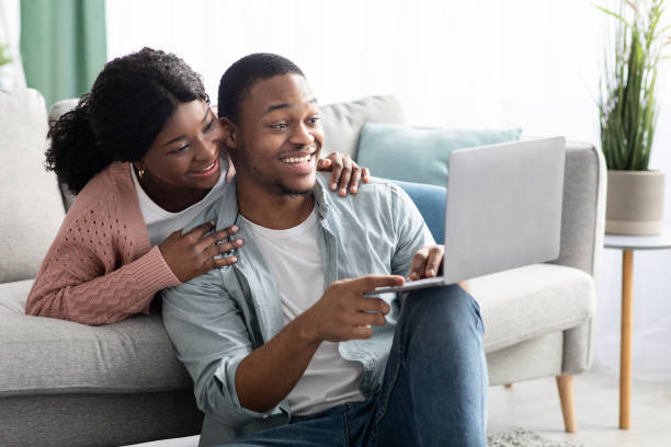 istock Happy black couple shopping online at home, using laptop 1322857343