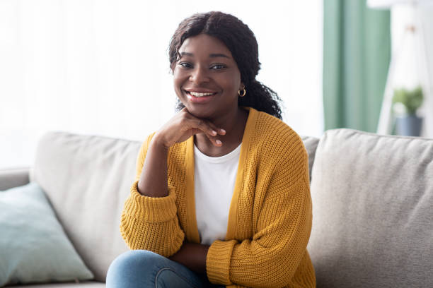 istock Attractive black lady posing on couch at home 1322858644