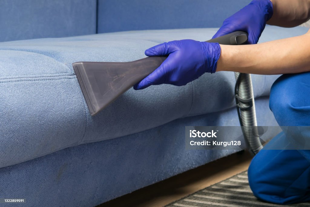 the old blue sofa is cleaned with a vacuum cleaner, with a wet cleaning function to restore the perfect look Cleaning Stock Photo the old blue sofa is cleaned with a vacuum cleaner, with a wet cleaning function to restore the perfect look Cleaning Stock Photo