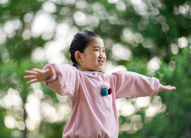 istock Little Girl Arms Raised Flying 1322861403