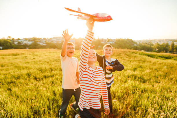 istock School-age boys launch a toy airplane. 1322864205