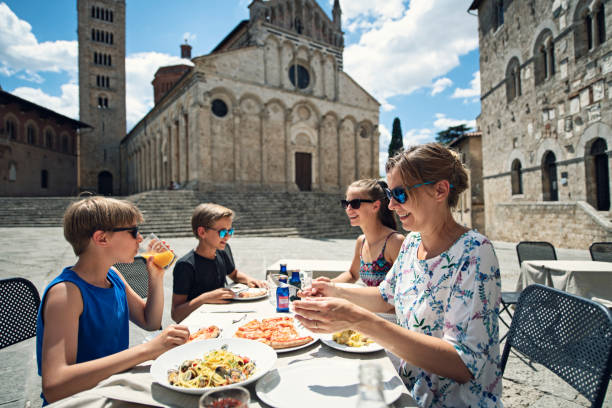 famiglia che si gode il pranzo un ristorante italiano - restaurant pasta italian culture dinner foto e immagini stock