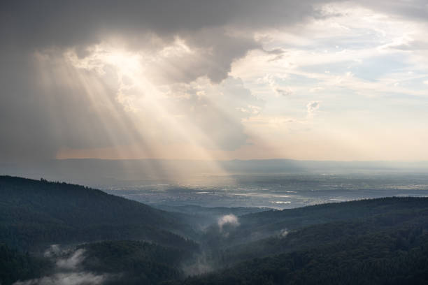 Sunbeams break through the cloud cover onto the rhine plain after a thunderstorm