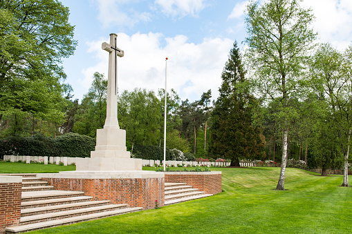 View at the remembrance cross and a number of grave stones on the Holten Canadian War Cemetery in The Netherlands. The cemetery is the last resting place for 1355 Canadian soldiers who fell in battle while liberating The Netherlands.