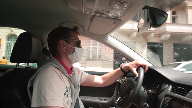 Driver man mask drives car city street Wearing mask face breathing protection