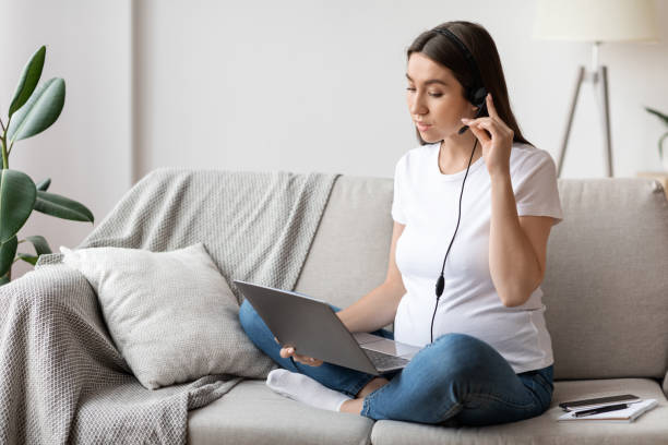 istock Pregnant Woman With Headset And Laptop At Home Study Or Working Remotely 1322870275