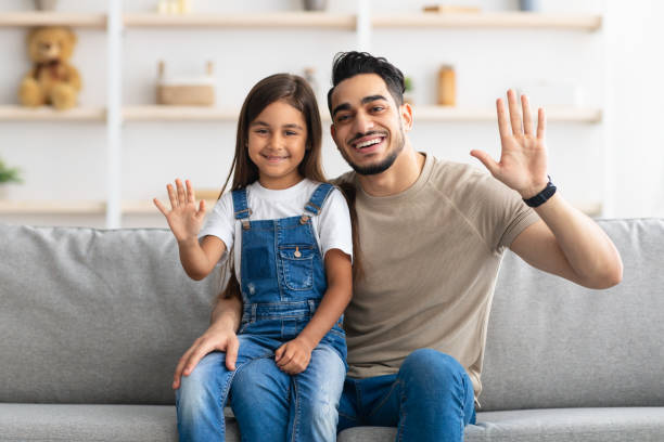 istock Family laptop waving hands and posing at camera 1322870360