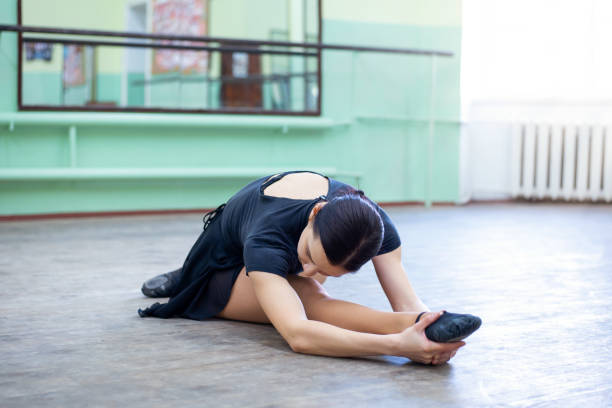 istock Young brunette female dancer making exercises in ballet studio 1322872312