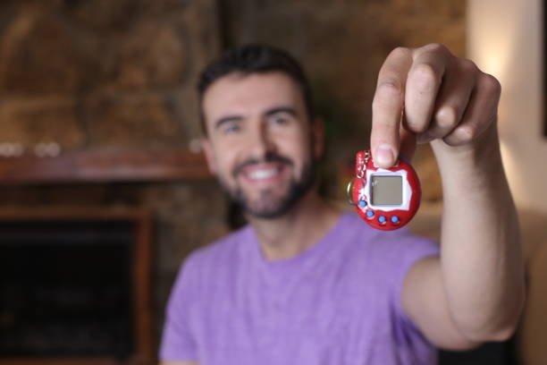 istock Millennial guy excited with his tamagochi 1322873091