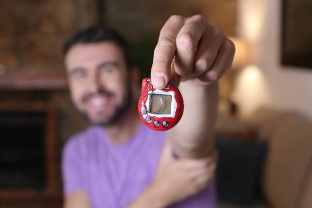 istock Millennial guy excited with his tamagochi 1322873147
