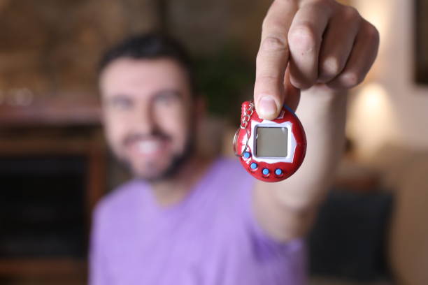istock Millennial guy excited with his tamagochi 1322873210