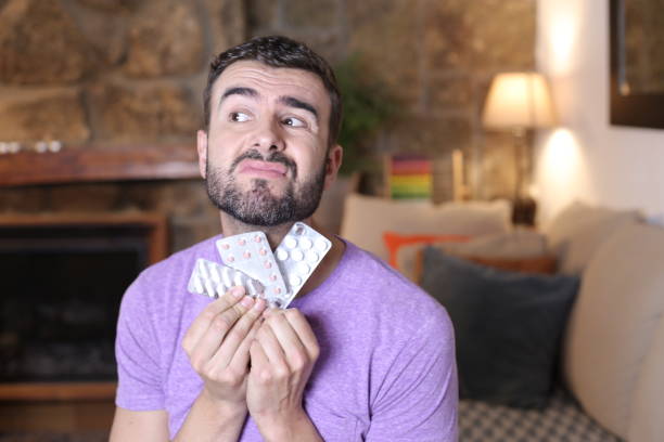 istock Confused man mixing a bunch of different pills 1322873215