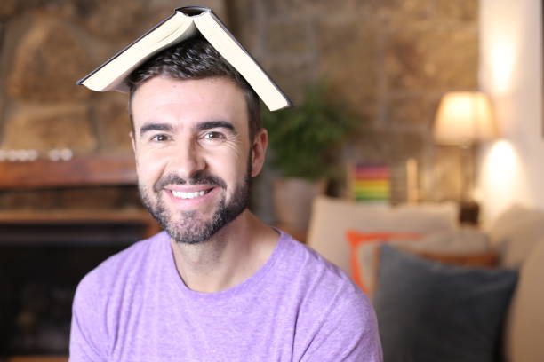 istock Happy young man with open book above head 1322873281