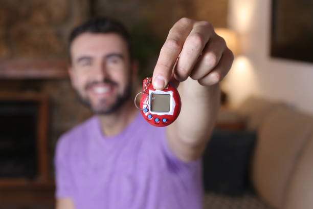 istock Millennial guy excited with his tamagochi 1322873309