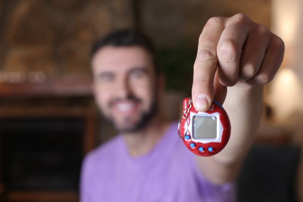 istock Millennial guy excited with his tamagochi 1322873368
