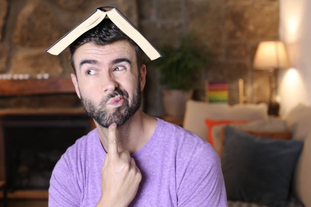 istock Pensive man with open book above head 1322873501
