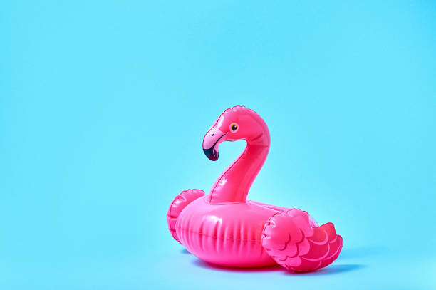 istock Inflatable pink flamingo pool toy on blue background. Creative minimal concept 1322873722