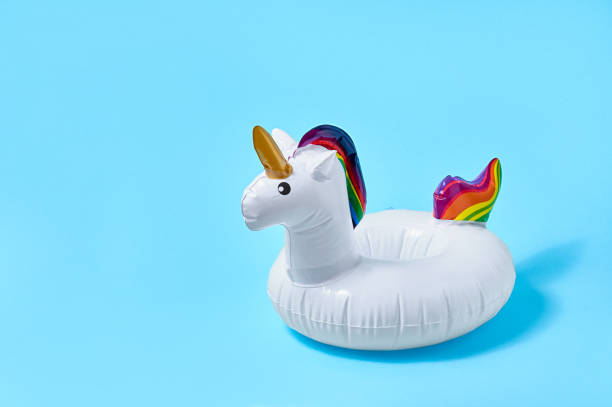 istock Inflatable white unicorn pool toy on blue background. Creative minimal concept 1322873723