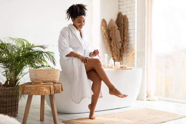 istock Black Lady Shaving Legs Using Razor Sitting In Bathroom Indoors 1322875457