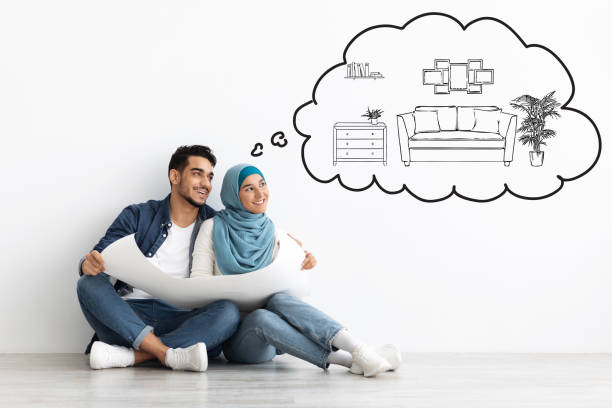 istock Dreaming muslim couple sitting on floor in empty apartment 1322877675