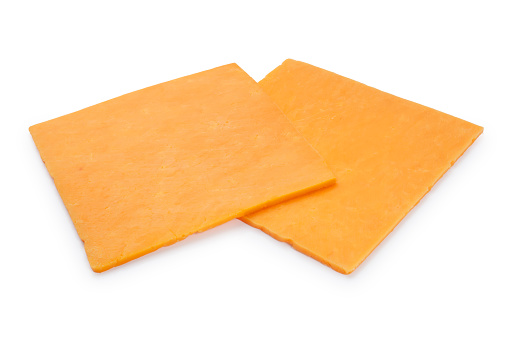 Studio shot of thinly sliced, square shaped, Red Leicester cheese cut out against a white background
