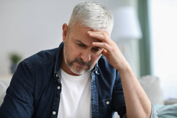 istock Frustrated senior man sitting on sofa, touching head 1322877794