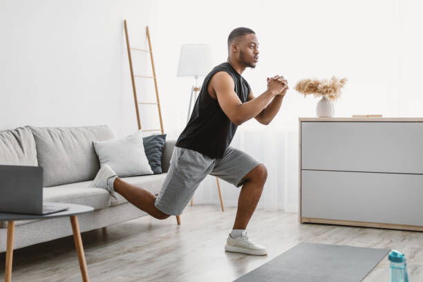 istock Sporty Black Guy Doing Single-Leg Squats Exercising Online At Home 1322878513