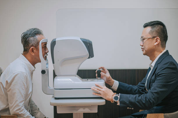 asian chinese senior aan having an eye exam at ophthalmologist's office asian chinese senior aan having an eye exam at ophthalmologist's office dilation stock pictures, royalty-free photos & images