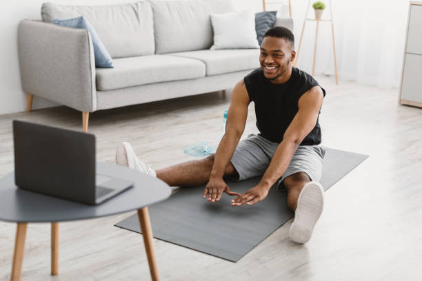 istock Black Man Doing Stretching Workout Exercise At Laptop At Home 1322879893