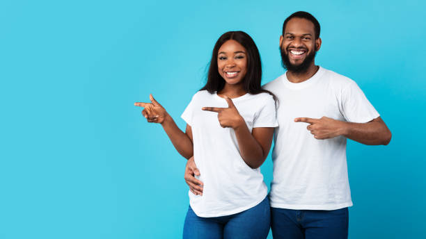 istock Smiling black couple pointing aside at free copy space 1322879972
