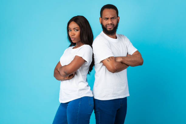 istock Afro couple standing back to back, blue studio background 1322880709