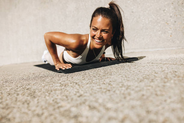 istock Smiling woman doing push ups on exercise mat 1322882586